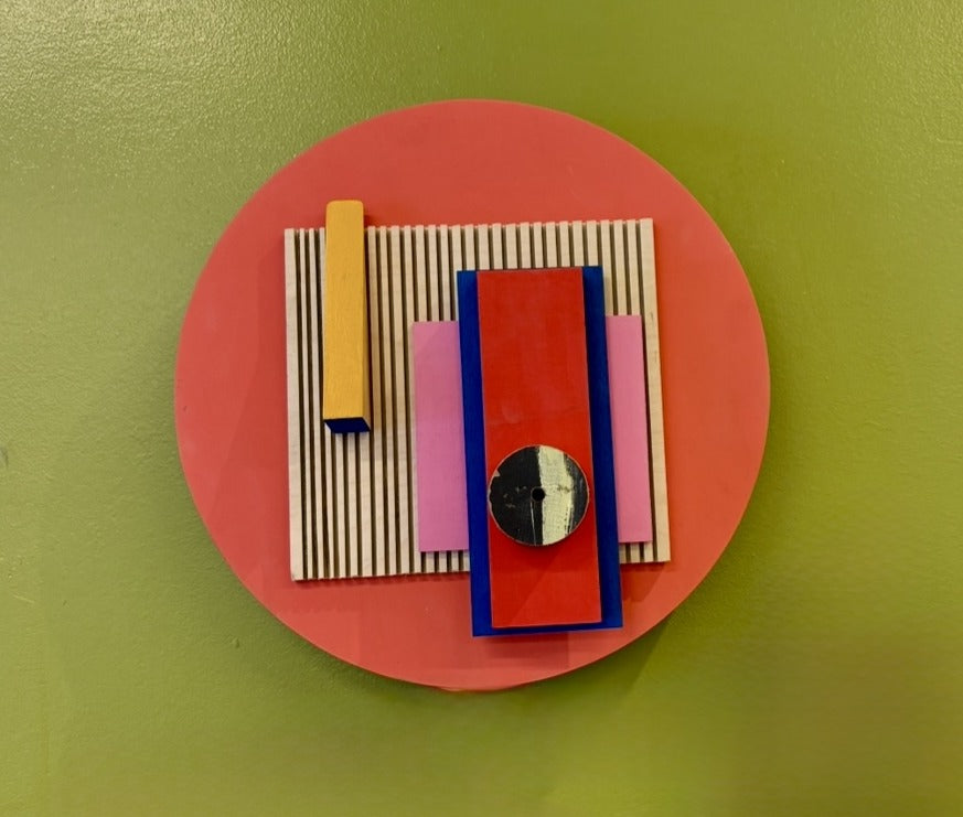 Red Hot by Nancy Benoy  - A Colorful geometric wall sculpture of shapes on a red background . Nancy Benoy is a featured artist for SOCIAL SPACE I Holiday Market at MRKT Box - Strathcona Market location from November 14 - 16,2025.