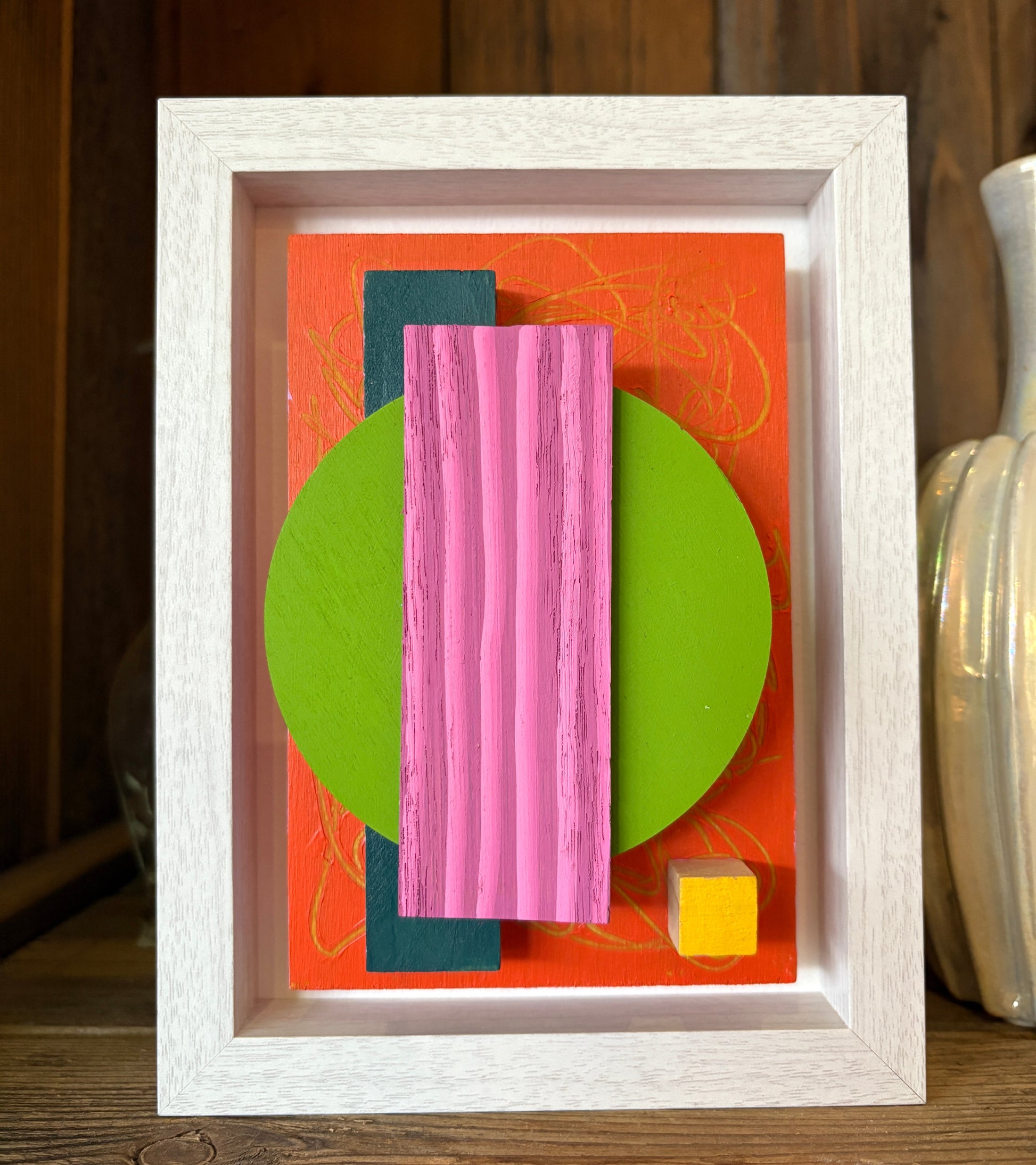 Mini Musings - Pretty Hottie by Nancy Benoy. Framed abstract art piece with colorful geometric shapes on an orange background . Nancy Benoy is a featured artist for SOCIAL SPACE I Holiday Market at MRKT Box - Strathcona Market location from November 14 - 16,2025.